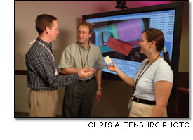Boeing Integrated Defense Systems engineers discuss a piece of insulating foam from the Space Shuttle external tank.