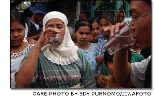 An Indonesian woman drinks clean, treated water